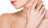 portrait of gentle young woman with healthy body touching her neck posing with face downwards