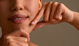 portrait of woman trying facial yoga massage